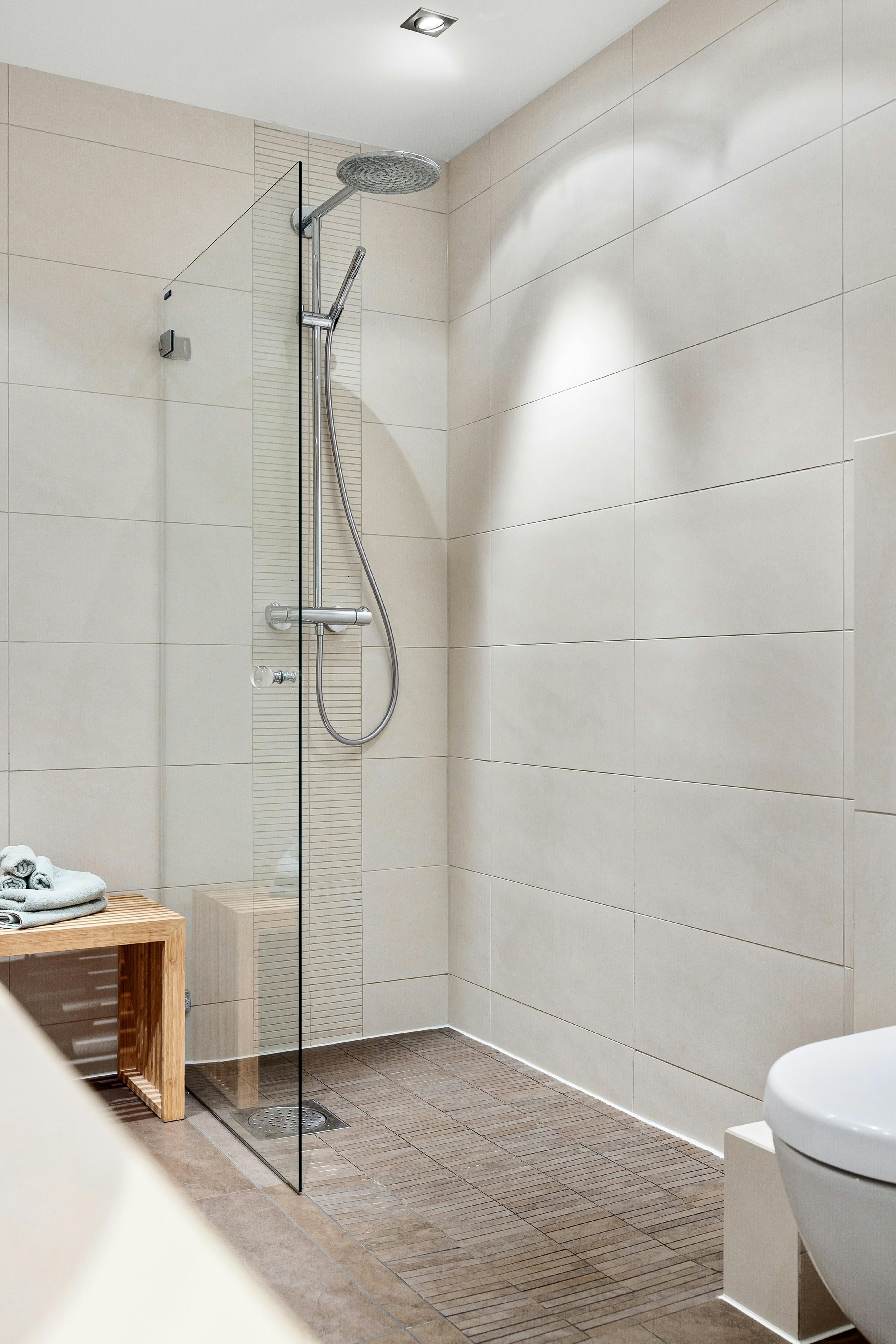 Bright premium bathroom with shower and light tile finish